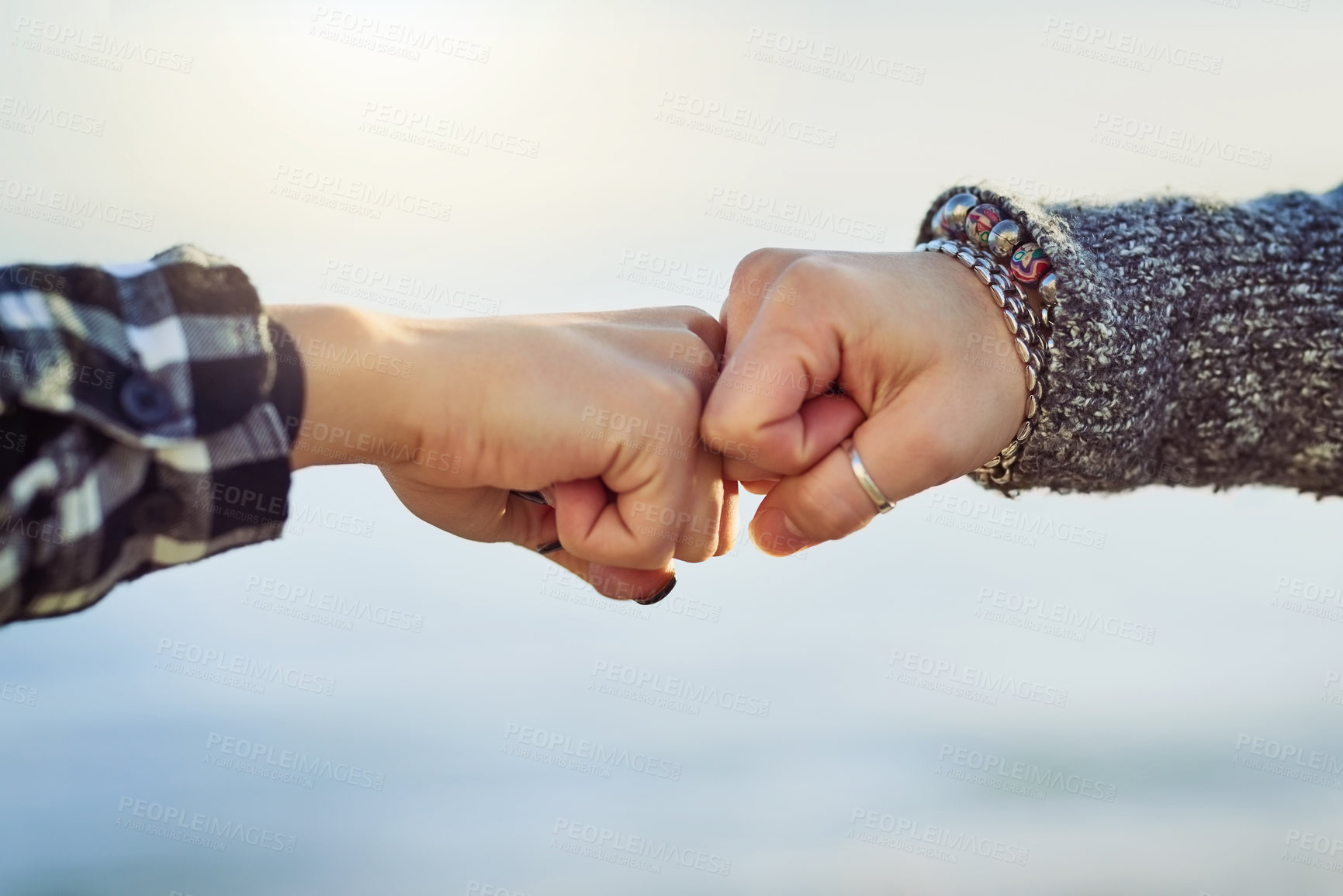 Buy stock photo Cropped shot of two unrecognizable women fist bumping outdoors