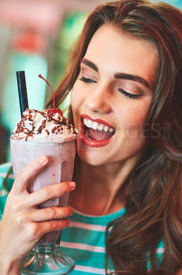 Buy stock photo Shot of a beautiful young woman drinking a milkshake in a diner