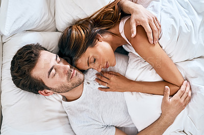 Buy stock photo High angle shot of a loving young couple sleeping together at home