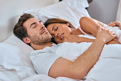 Buy stock photo Shot of a loving young couple sleeping together at home