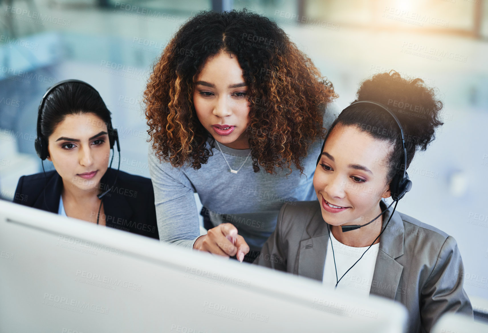Buy stock photo Shot of a young woman assisting her colleagues in a call centre