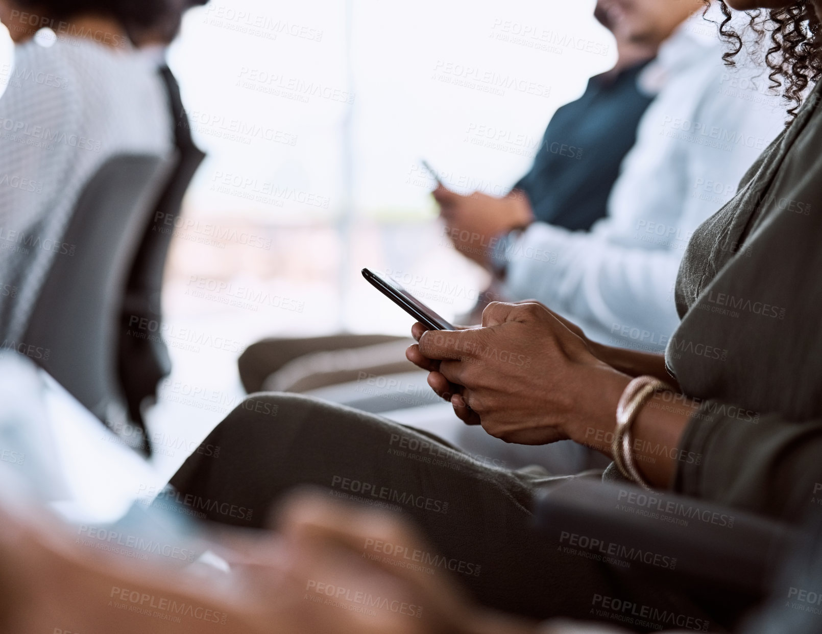 Buy stock photo Cropped shot of a group of businesspeople using their mobile phones during a conference