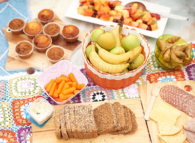 Buy stock photo Food, picnic and snack table outdoor with fruit, bread and lunch for party and social event in park. Cheese board, sunshine and meal with meat, muffins and salami spread in summer with platter