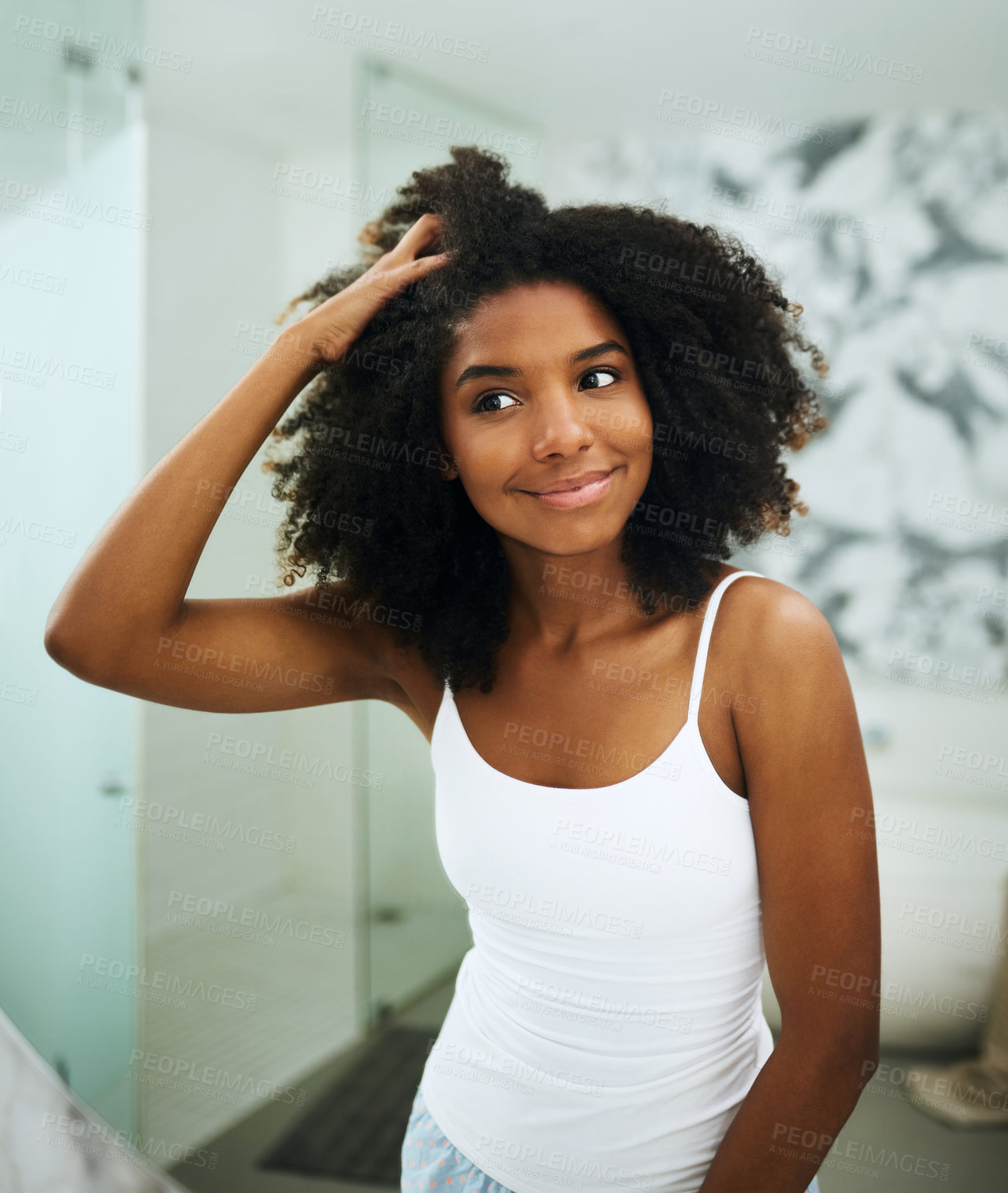 Buy stock photo Shot of an attractive young woman looking at her face in the mirror at home