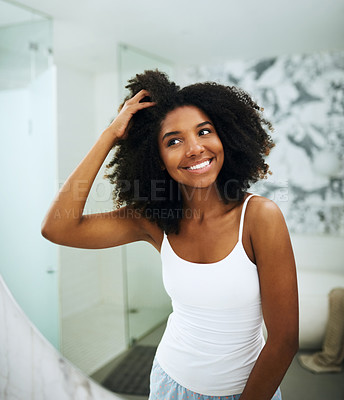 Buy stock photo Shot of an attractive young woman looking at her face in the mirror at home