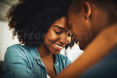 Buy stock photo Shot of a cheerful young couple holding each other and sharing a tender moment in the kitchen at home during the day