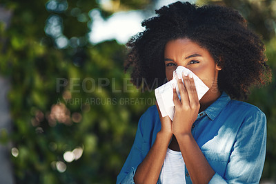 Buy stock photo Portrait of a young woman blowing her nose with a tissue outside