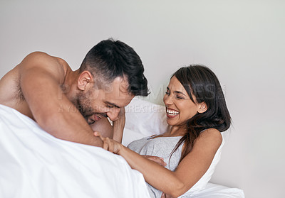 Buy stock photo Cropped shot of an affectionate young married couple in bed at home