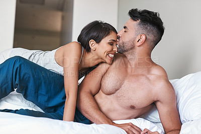 Buy stock photo Cropped shot of an affectionate young married couple in bed at home