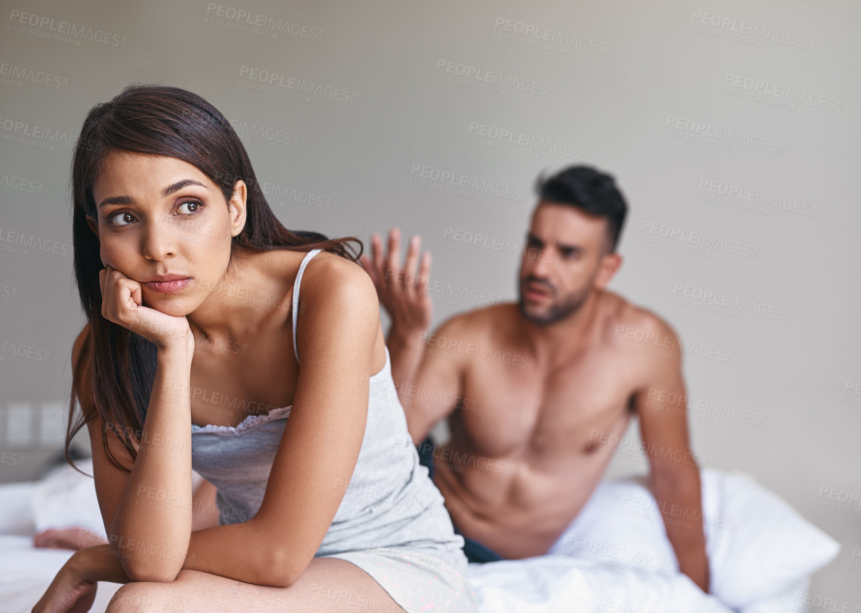Buy stock photo Cropped shot of a young married couple having a disagreement in their bedroom at home