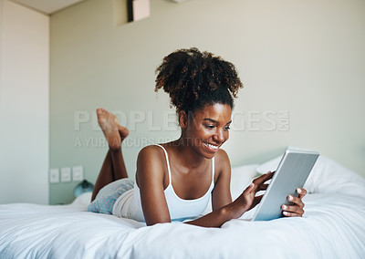 Buy stock photo Shot of a young beautiful woman using a tablet in her bedroom at home