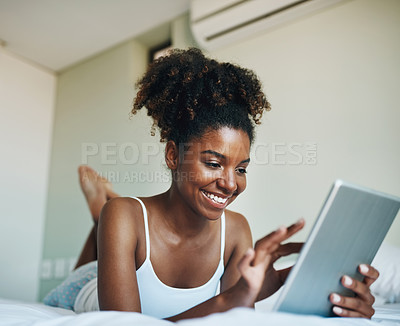 Buy stock photo Shot of a young beautiful woman using a tablet in her bedroom at home
