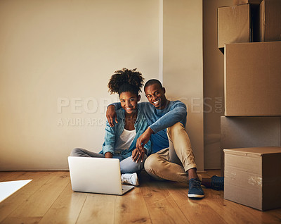 Buy stock photo Portrait of a cheerful young couple browsing on a laptop together while being surrounded by cardboard boxes inside at home