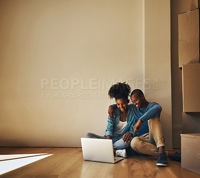 Buy stock photo Shot of a cheerful young couple browsing on a laptop together while being surrounded by cardboard boxes inside at home