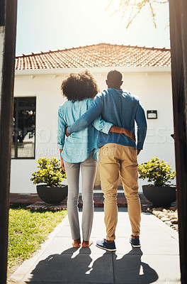 Buy stock photo Rearview shot of an unrecognizable couple holding each other while standing and looking at their new home