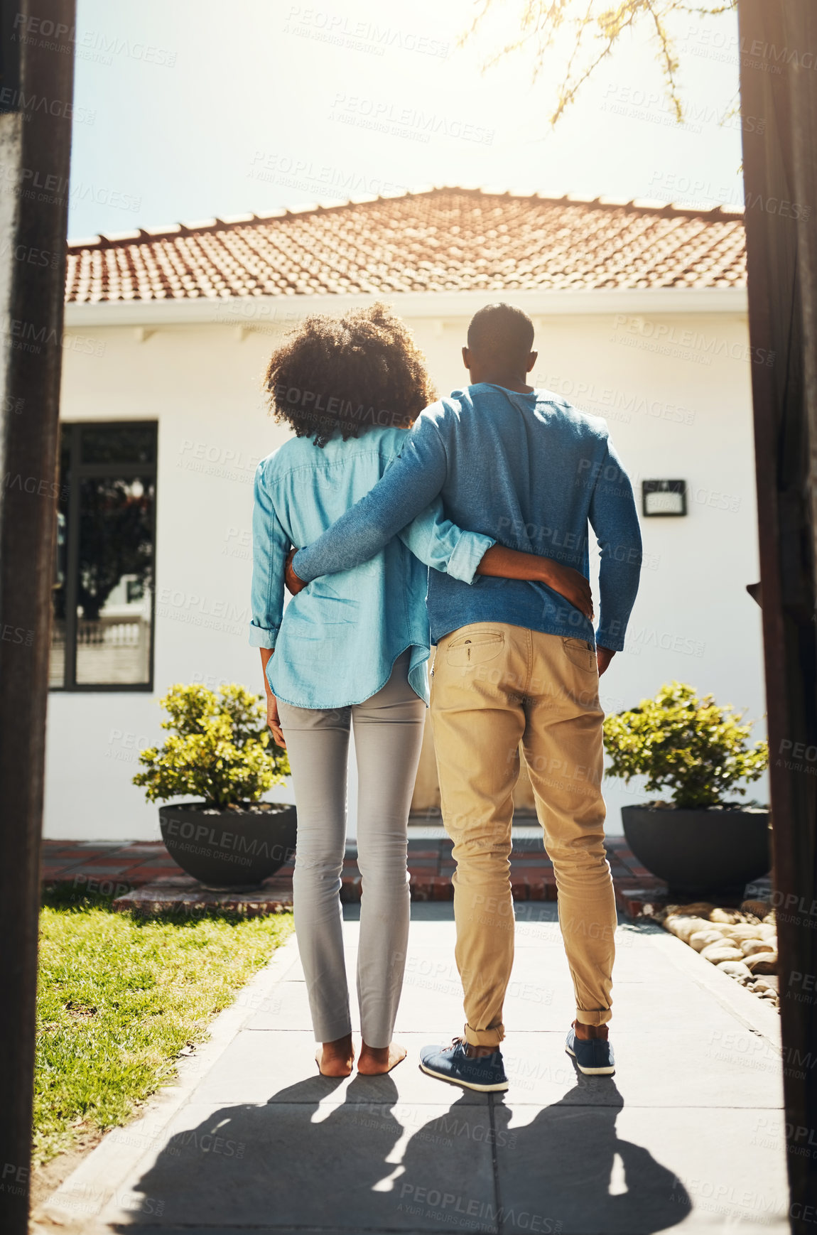 Buy stock photo Rearview shot of an unrecognizable couple holding each other while standing and looking at their new home