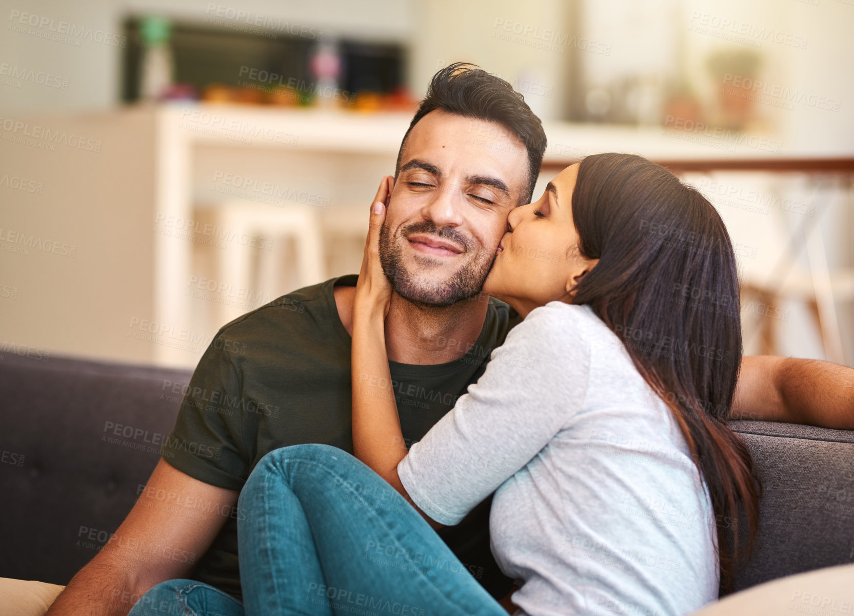 Buy stock photo Couple, relax and kiss on couch at house with love, bonding together and healthy relationship for security. Smile, people and affection with calm morning, romance and partner gratitude for commitment