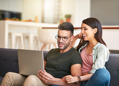 Buy stock photo Shot of a young couple using a laptop together at home