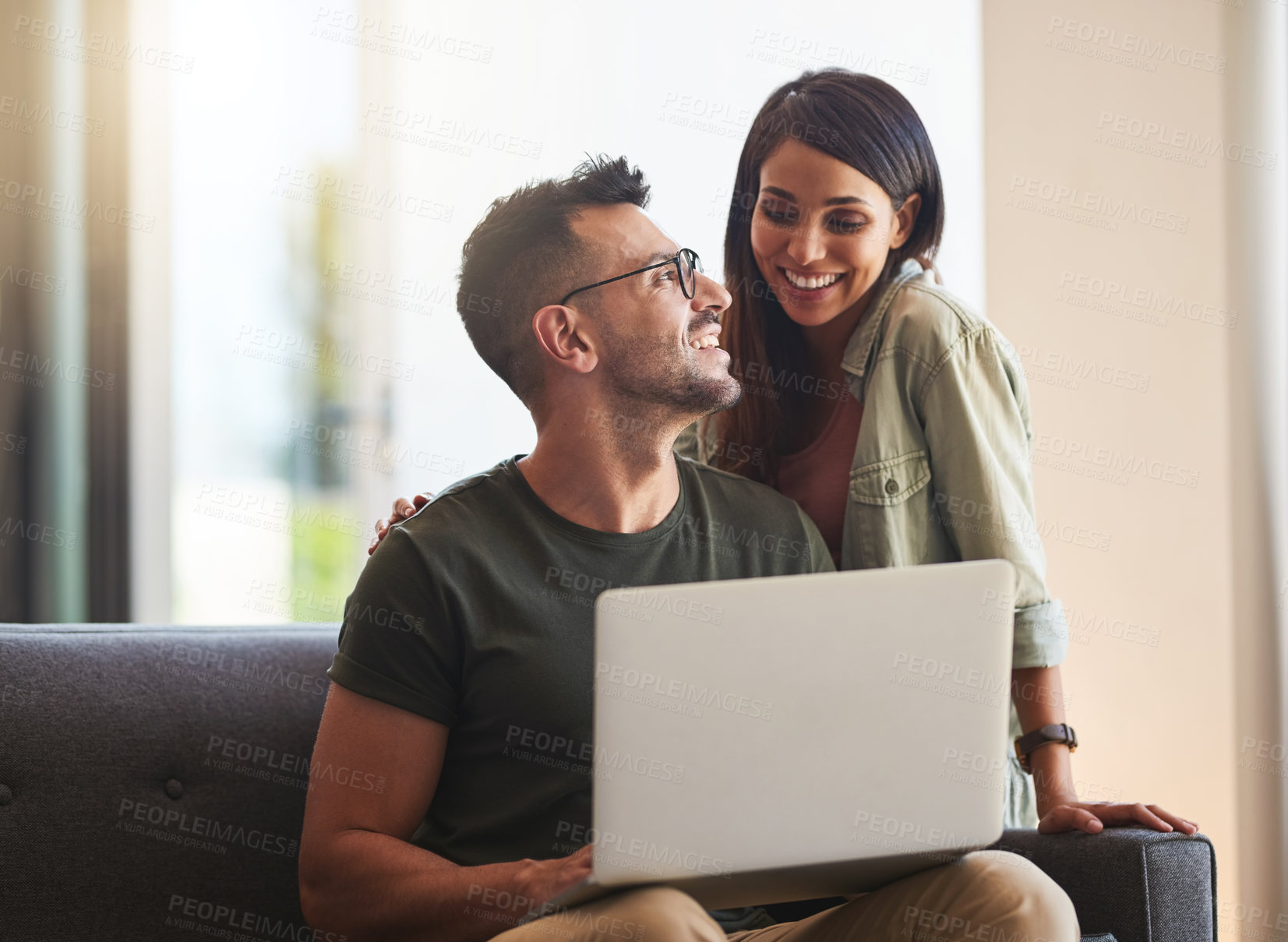 Buy stock photo Shot of a young couple using a laptop together at home