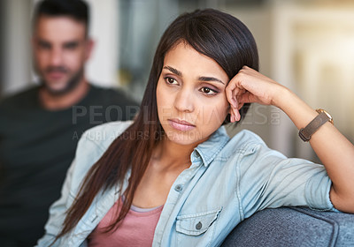 Buy stock photo Shot of a young woman looking upset after having a fight with her partner at home