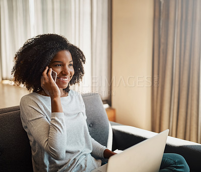 Buy stock photo Shot of an attractive young woman talking on a cellphone while using a laptop at home