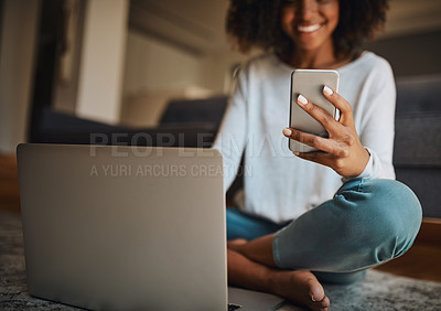 Buy stock photo Shot of an attractive young woman using a cellphone and laptop at home