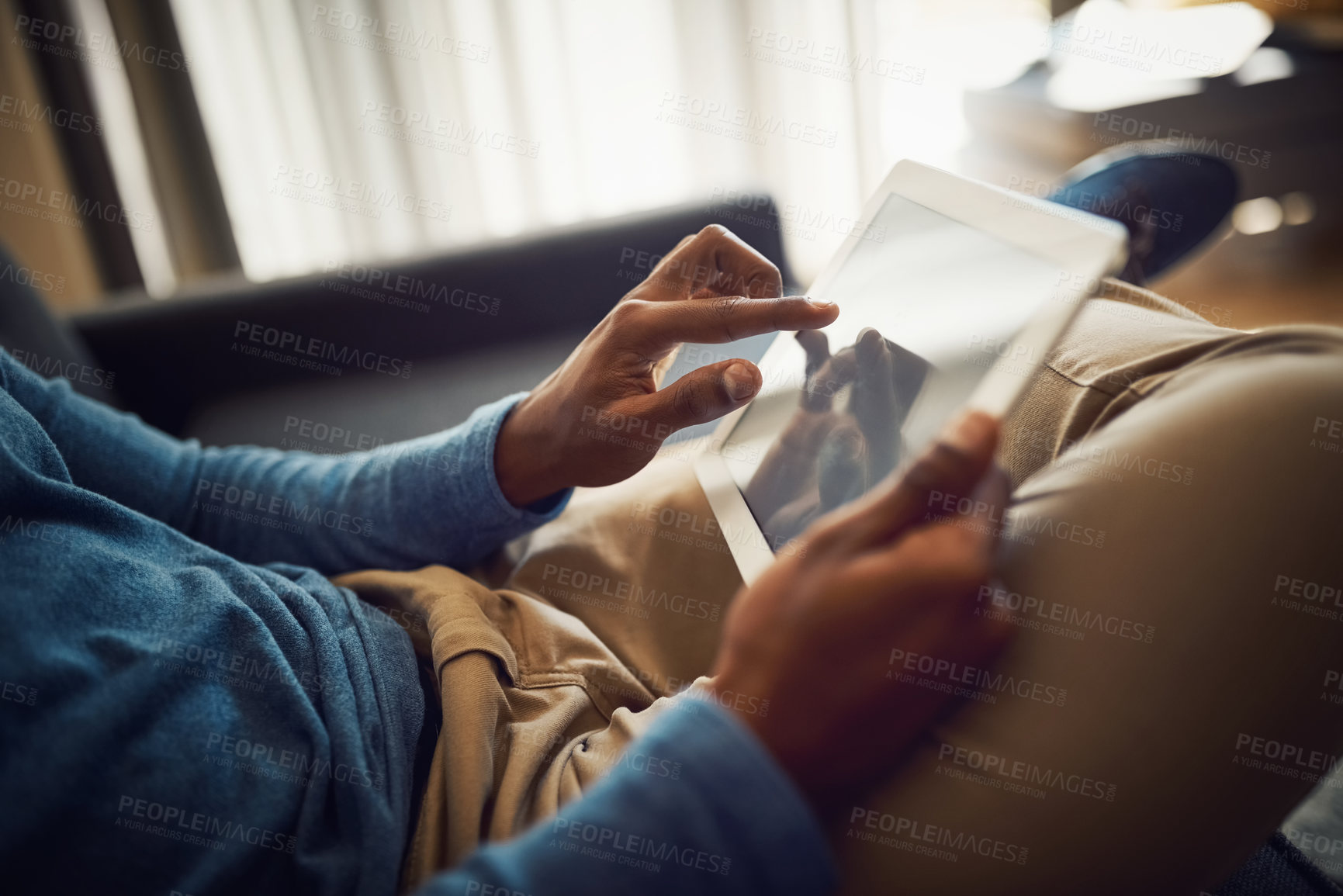 Buy stock photo Closeup shot of an unrecognizable man using a digital tablet at home