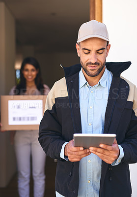 Buy stock photo Shot of a courier using a digital tablet while making a delivery to a customer