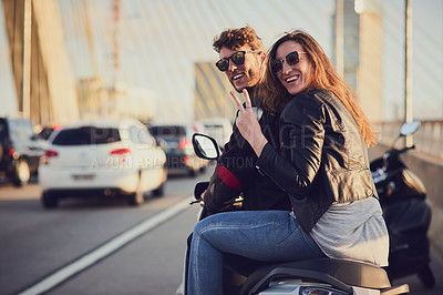 Buy stock photo Rearview shot of a young attractive couple riding a scooter around town