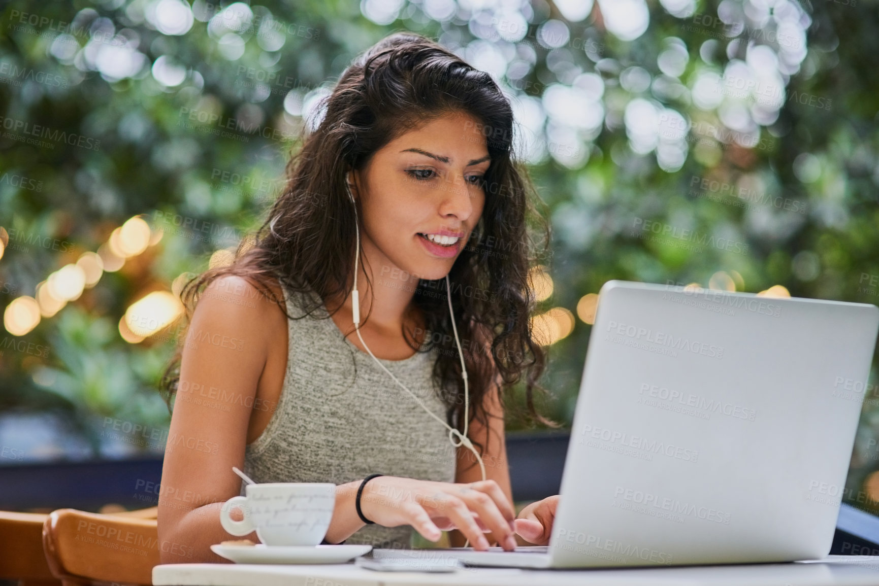 Buy stock photo Shot of an attractive young woman using a laptop at a cafe