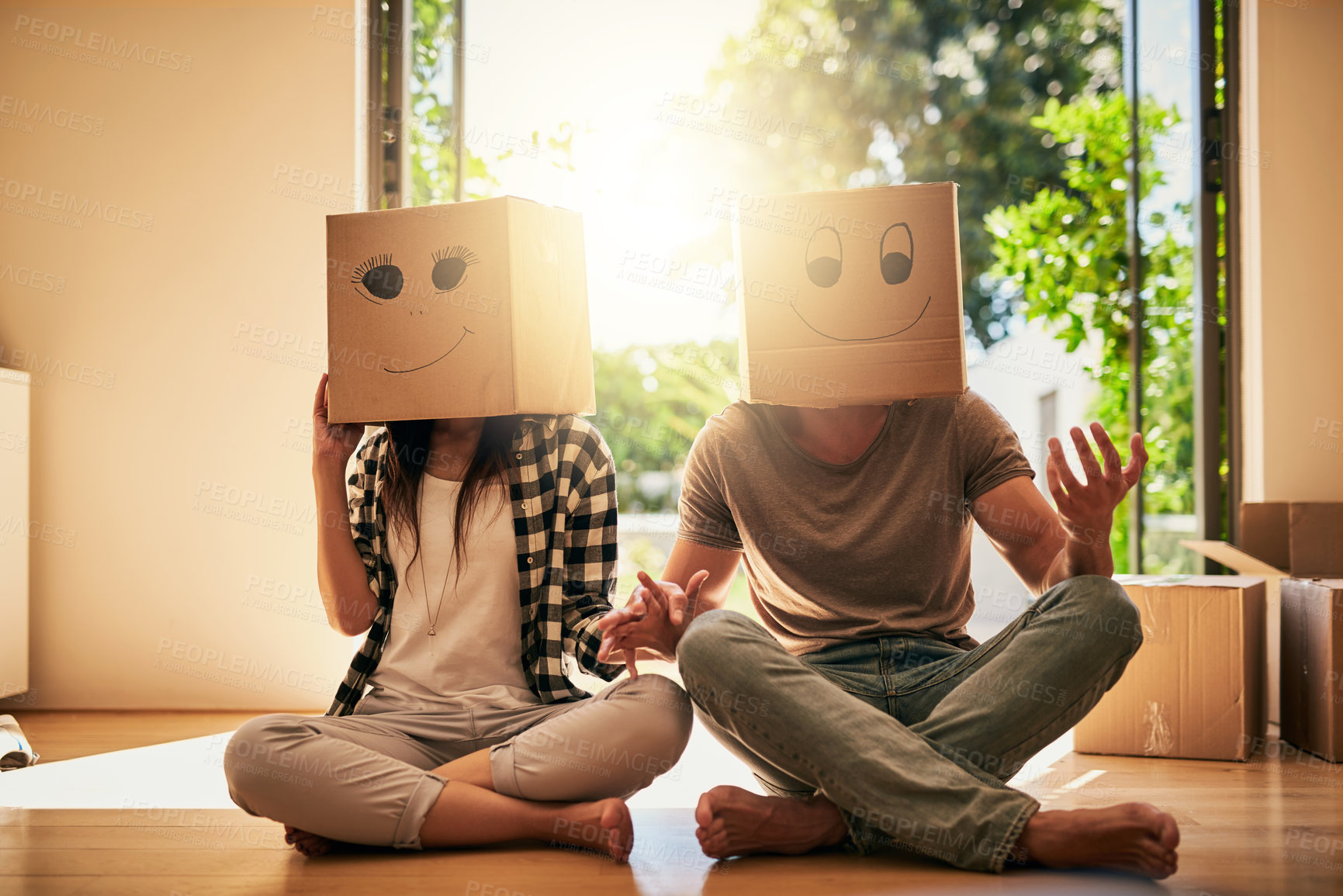 Buy stock photo Playful, couple and cardboard with boxes on head for moving day, comedy renovation and property investment. People, funny drawing and new house with future security, comic celebration and emoji game 