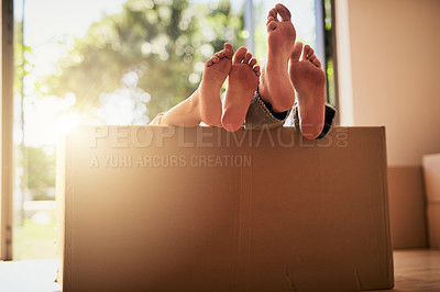 Buy stock photo Shot of an unidentifiable couple lying in a box together with their feet sticking out