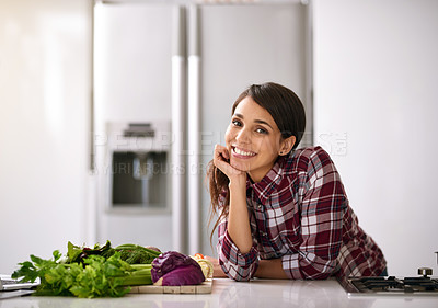 Buy stock photo Cropped shot of an attractive young woman cooking in the kitchen at home