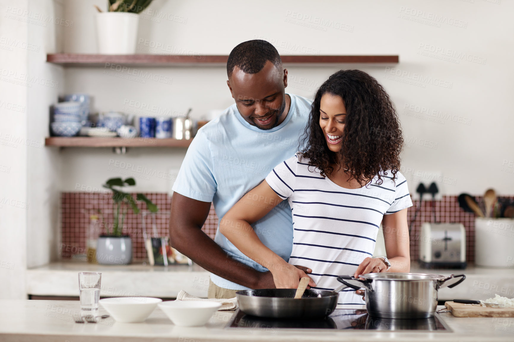 Buy stock photo Home, kitchen and couple with pan for cooking, support and bonding together with sharing activity. African people, man and woman cook with culinary skills for meal, food and embrace with hug