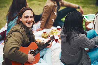 Buy stock photo Portrait of a cheerful young man about to play guitar at a picnic with his friends outside during the day