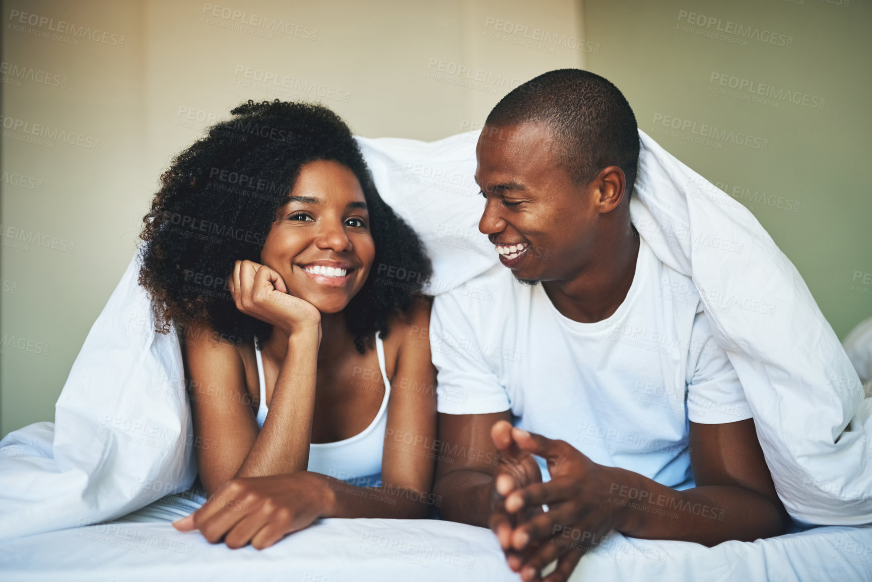 Buy stock photo Blanket, love and smile of couple in bedroom of home together for morning bonding or romance. Comfort, face and relax with happy African man and woman in bed for anniversary, holiday or vacation