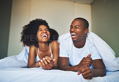 Buy stock photo Shot of a happy young couple relaxing under a duvet in their bedroom