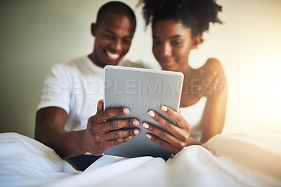 Buy stock photo Tablet, bedroom and happy couple in home with movie, video or communication on social media app. Black man, woman and digital touchscreen in house with reading, online chat or smile at meme together