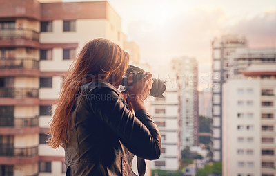 Buy stock photo Cropped shot of a young woman taking photographs of the city with a camera outside