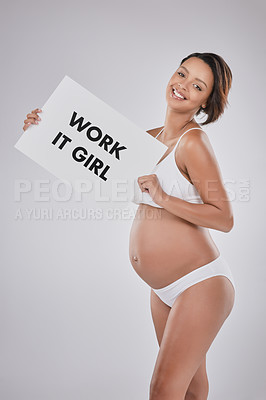 Buy stock photo Studio portrait of a beautiful young pregnant woman holding a sign with the word, “Work it girl” on it