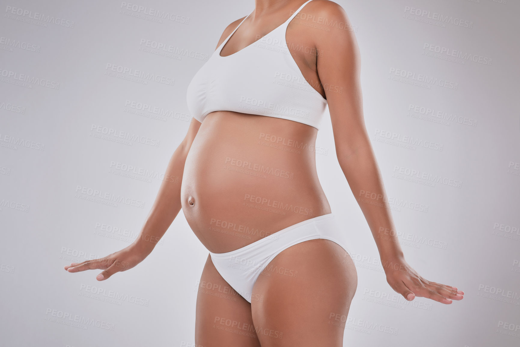 Buy stock photo Stomach, growth and pregnant woman in studio with skincare, wellness and body development in maternity. Pregnancy, shape and girl with self care for stretch marks, healthy skin and white background