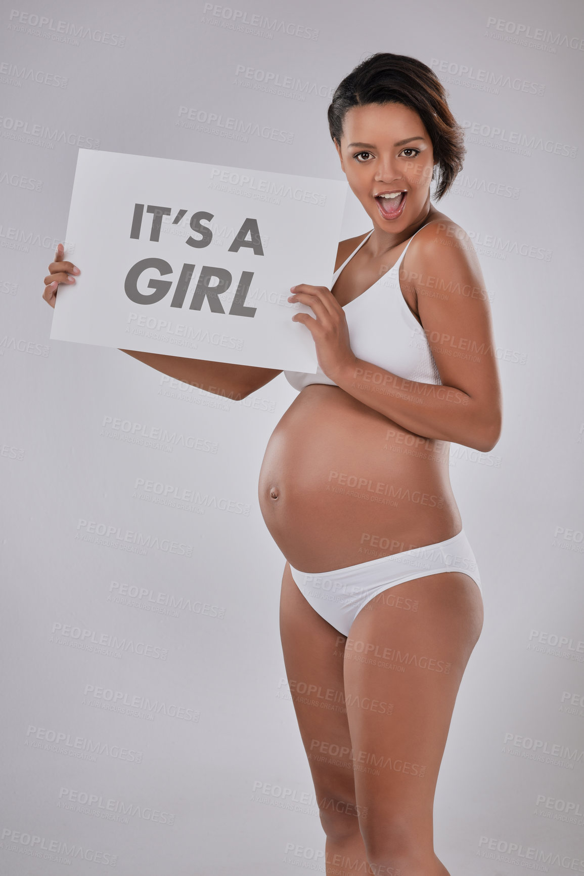 Buy stock photo Pregnant woman, sign and happy in studio for gender reveal, underwear and wow in portrait by white background. Body, smile and excited with poster, board and announcement for baby girl in Colombia