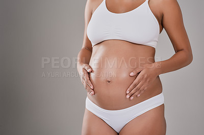 Buy stock photo Cropped studio shot of a pregnant woman wearing wearing underwear against a gray background