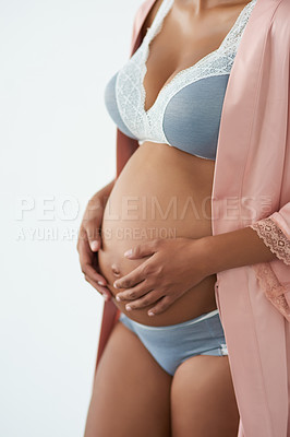 Buy stock photo Studio shot of a pregnant young woman standing against a white background