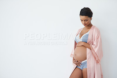 Buy stock photo Studio shot of a pregnant young woman standing against a white background