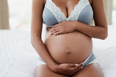 Buy stock photo Shot of a pregnant young woman relaxing on her bed at home