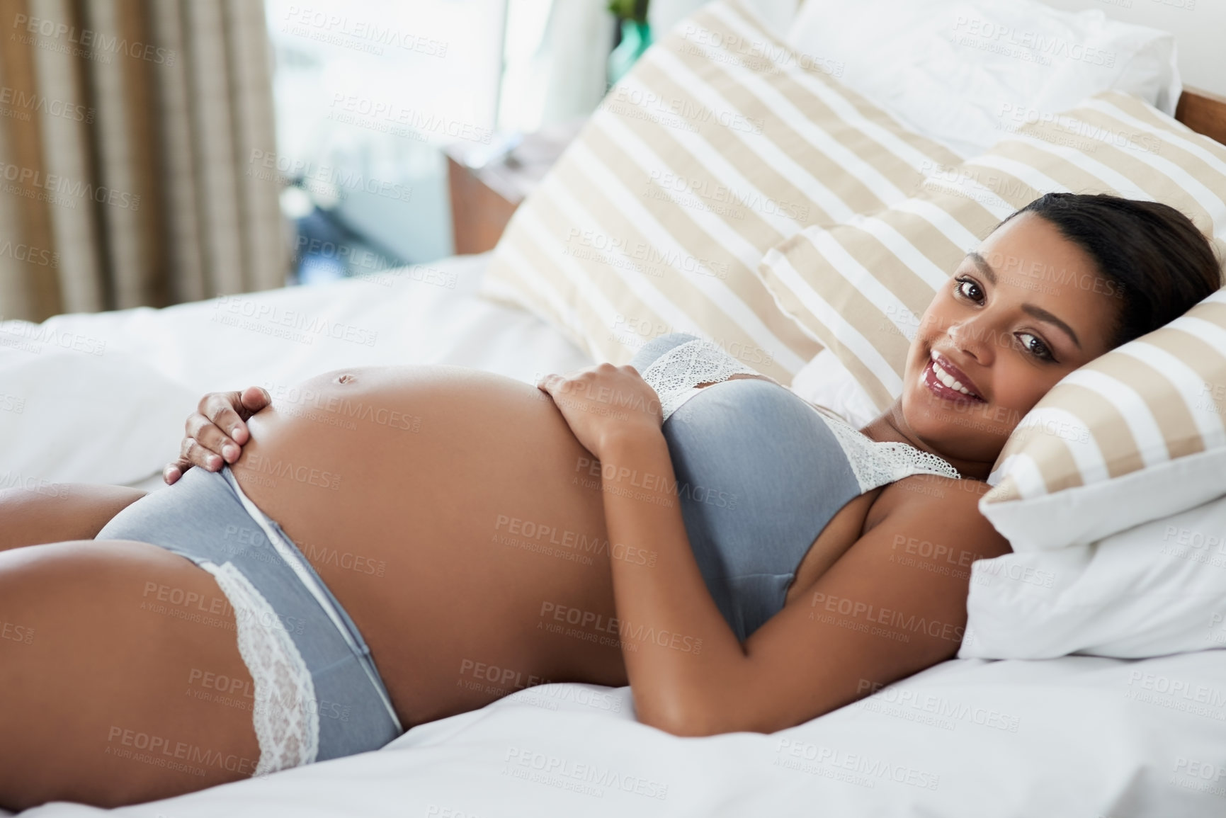 Buy stock photo Pregnancy, happy and portrait of woman in bedroom for love, prenatal care and maternity. Pregnant belly, home and person in underwear on bed for rest, relax and calm for health, wellness or fertility