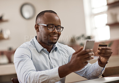 Buy stock photo Cropped shot of a handsome young businessman sending a text message while working at home