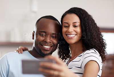 Buy stock photo Cropped shot of a young married couple taking a selfie in the kitchen at home