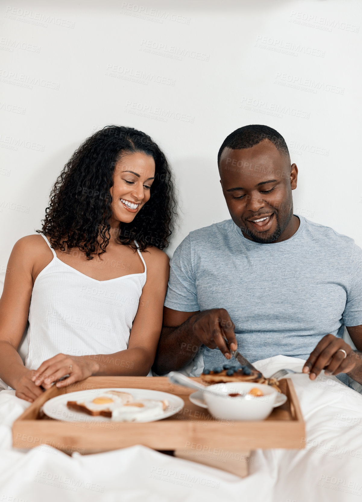 Buy stock photo Couple, relax and happy breakfast in bed, morning date and healthy nutrition in hotel room. People, talking and romance in relationship on weekend for bonding, eating together and comfortable in home